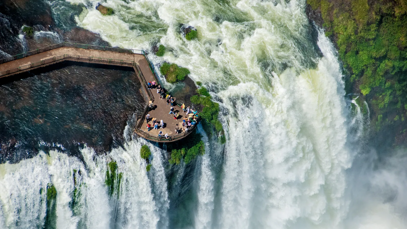 Mirante da passarela das Cataratas do Iguaçu visto do alto, com visitantes na beira das quedas